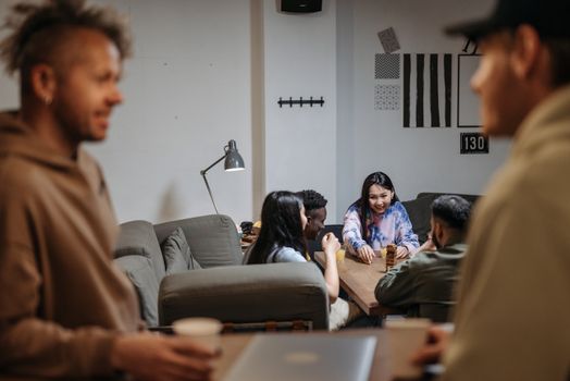 Group of friends enjoying a casual evening indoors, chatting and laughing.