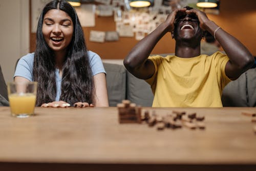 Man and Woman Playing Wooden Blocks Game