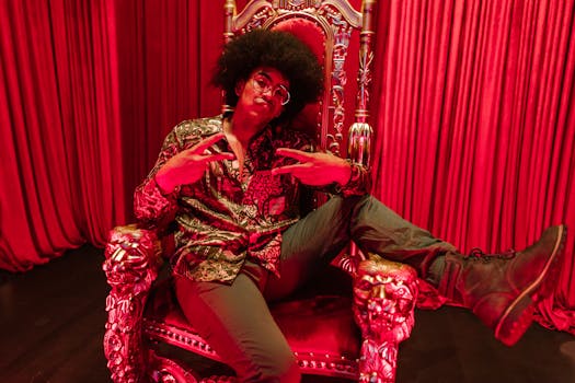 Stylish individual poses in luxurious setting with red velvet backdrop.