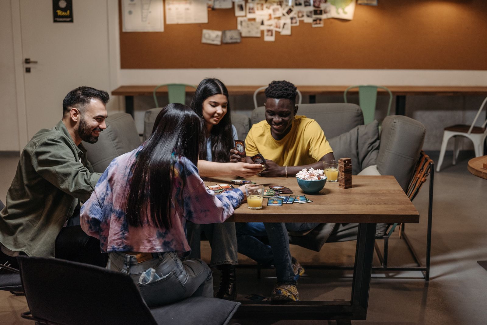 A small group of friends playing cards together at a table.