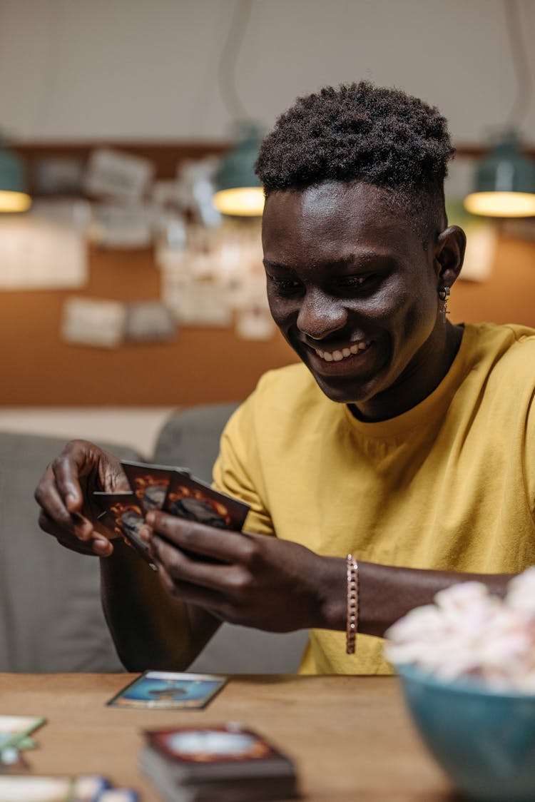 A Smiling Man Playing A Card Game