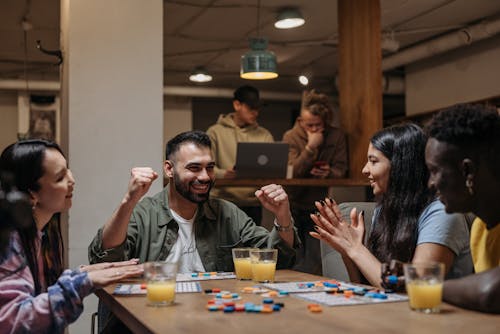 Smiling Friends Playing Board Game on Table