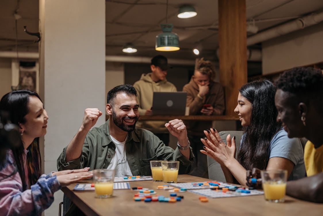 Smiling Friends Playing Board Game on Table