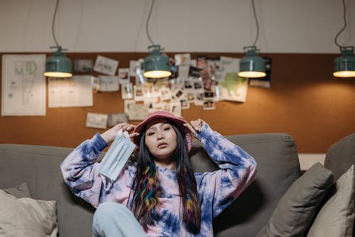 Free Woman in Pink Hat Sitting on Couch  Stock Photo