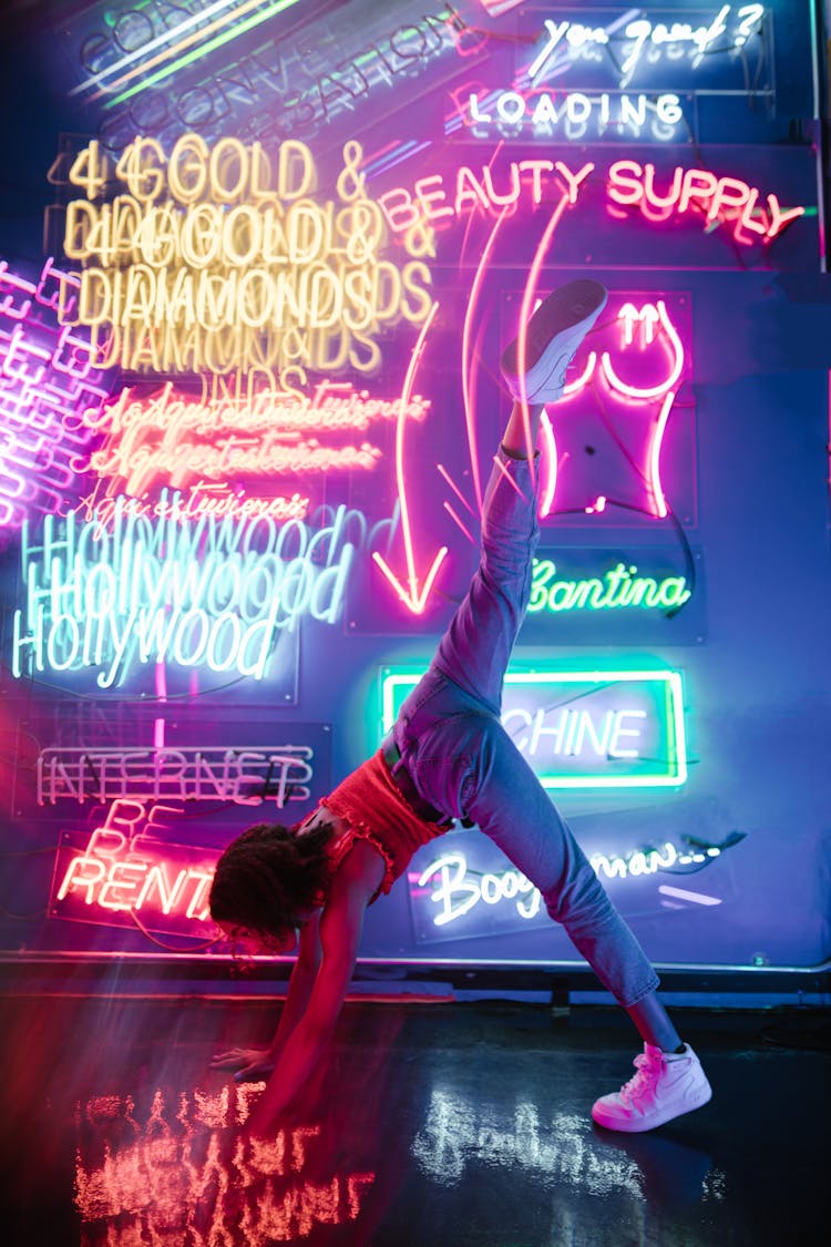 Woman Doing Sport Pose Near Neon Sign