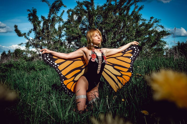 Woman In Butterfly Costume In Nature Landscape