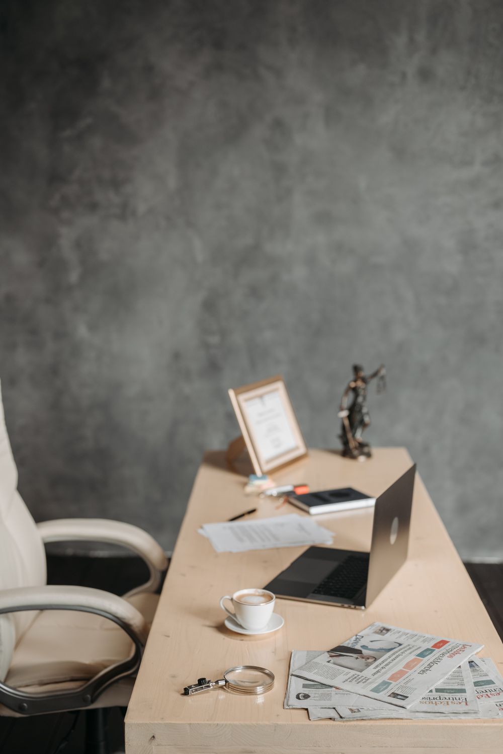 Aufgeräumter Schreibtisch mit Laptop und Kaffee in einem modernen Büro