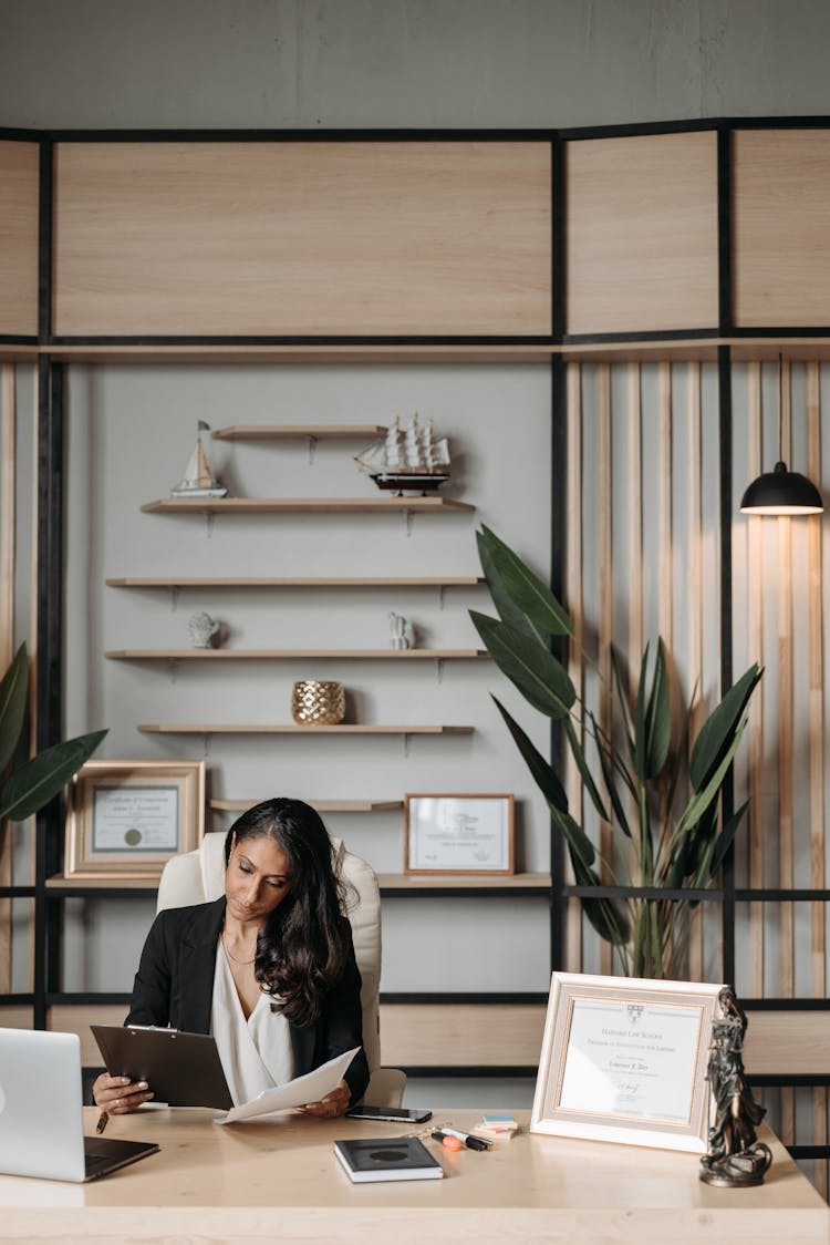 
A Woman Reading Documents In Her Office