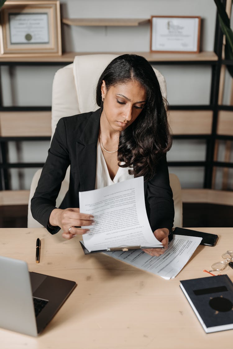 
A Woman Reading Documents In Her Office