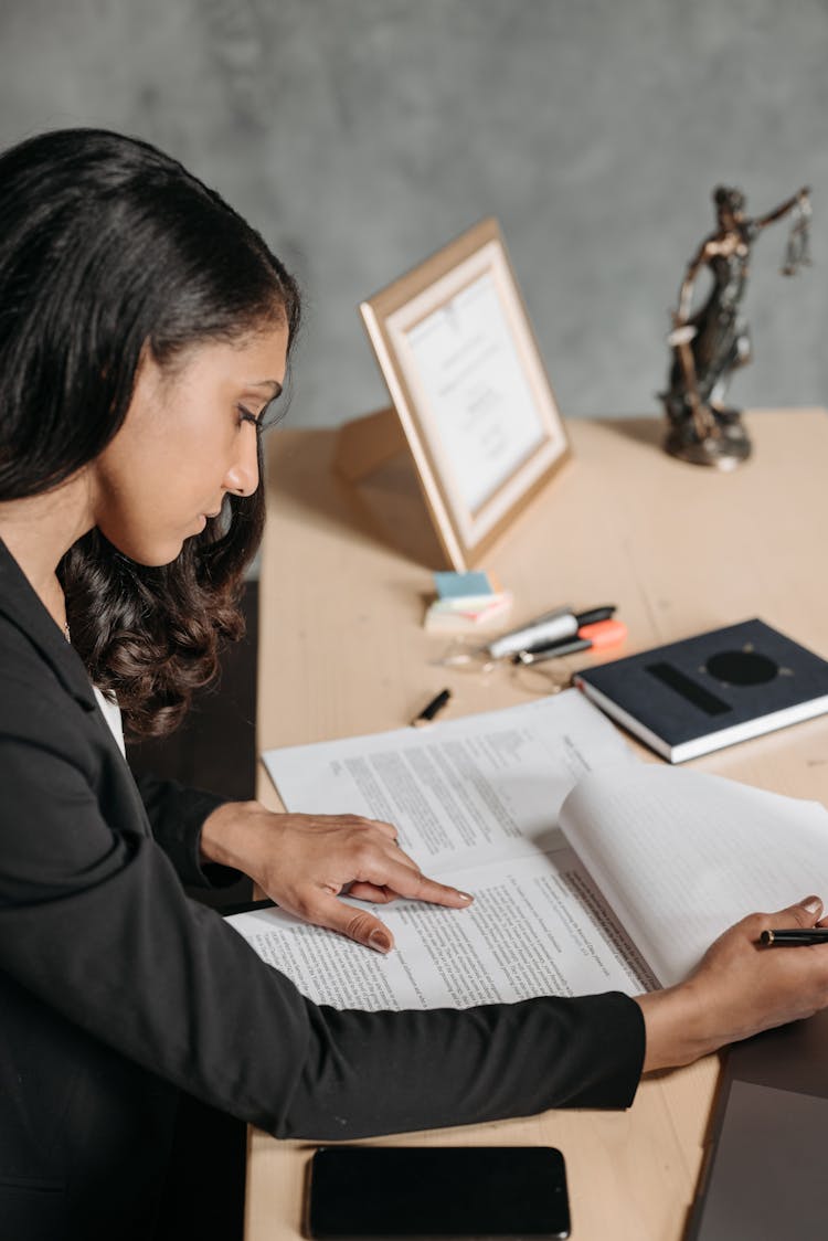 
A Woman Reading Documents In Her Office