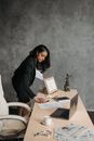 Woman in Black Blazer Sitting on White Plastic Chair