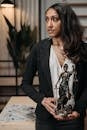 Woman in Black Blazer Sitting by the Table