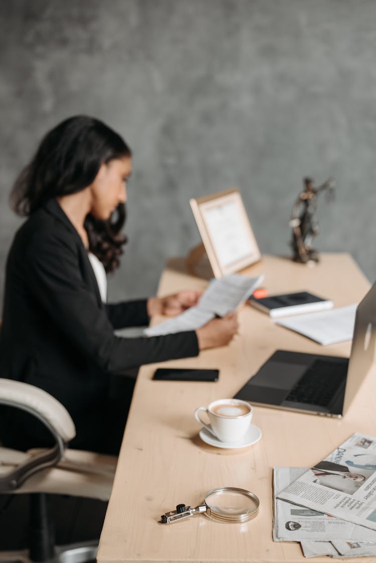 Woman In Black Blazer Reading The Papers