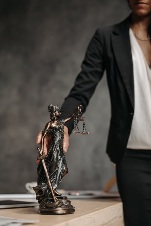 Woman Hand Holding Justice Figurine