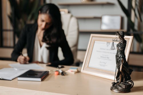 Free Lady Justice Figurine on Wooden Table Stock Photo