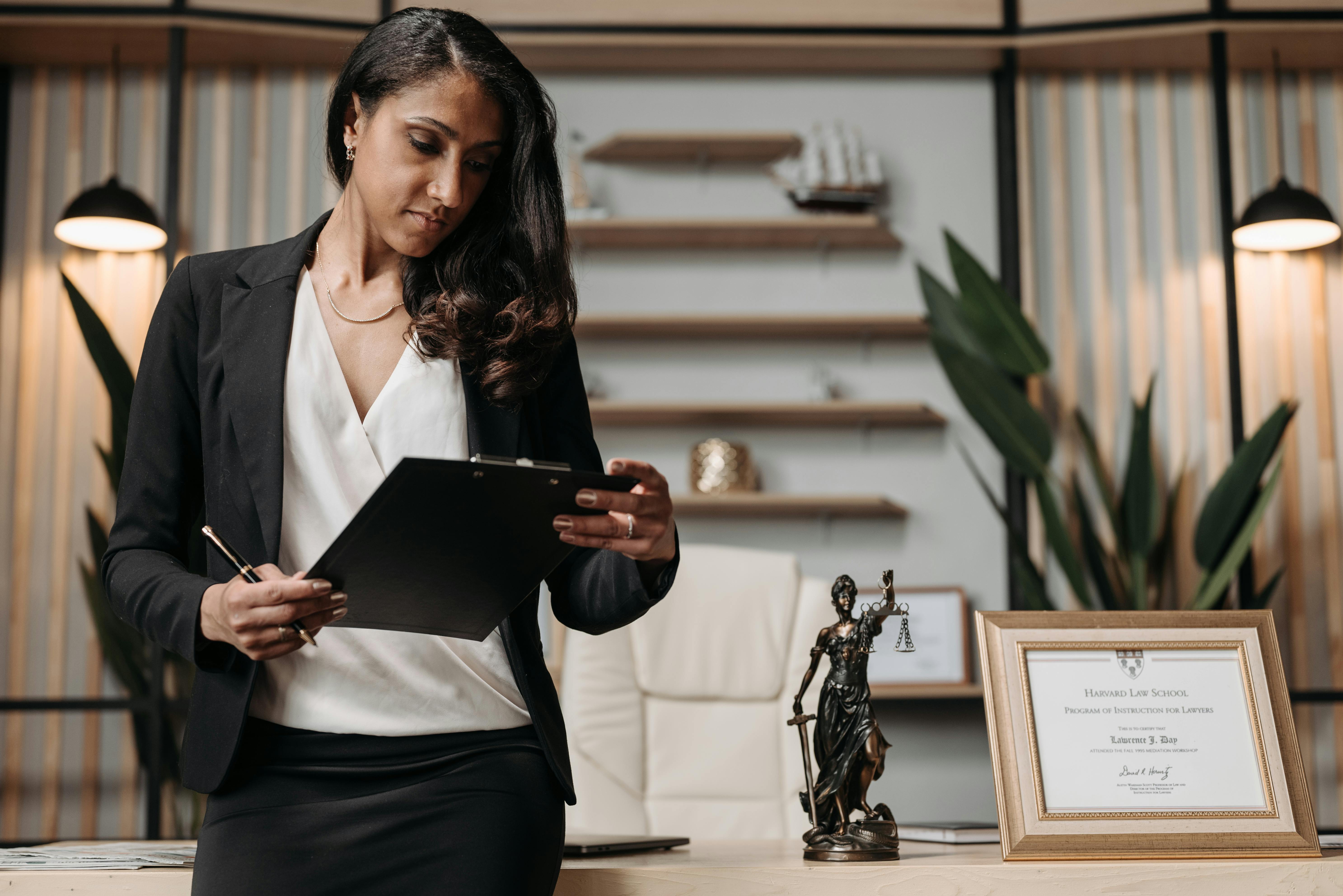 a woman in black blazer holding a clipboard