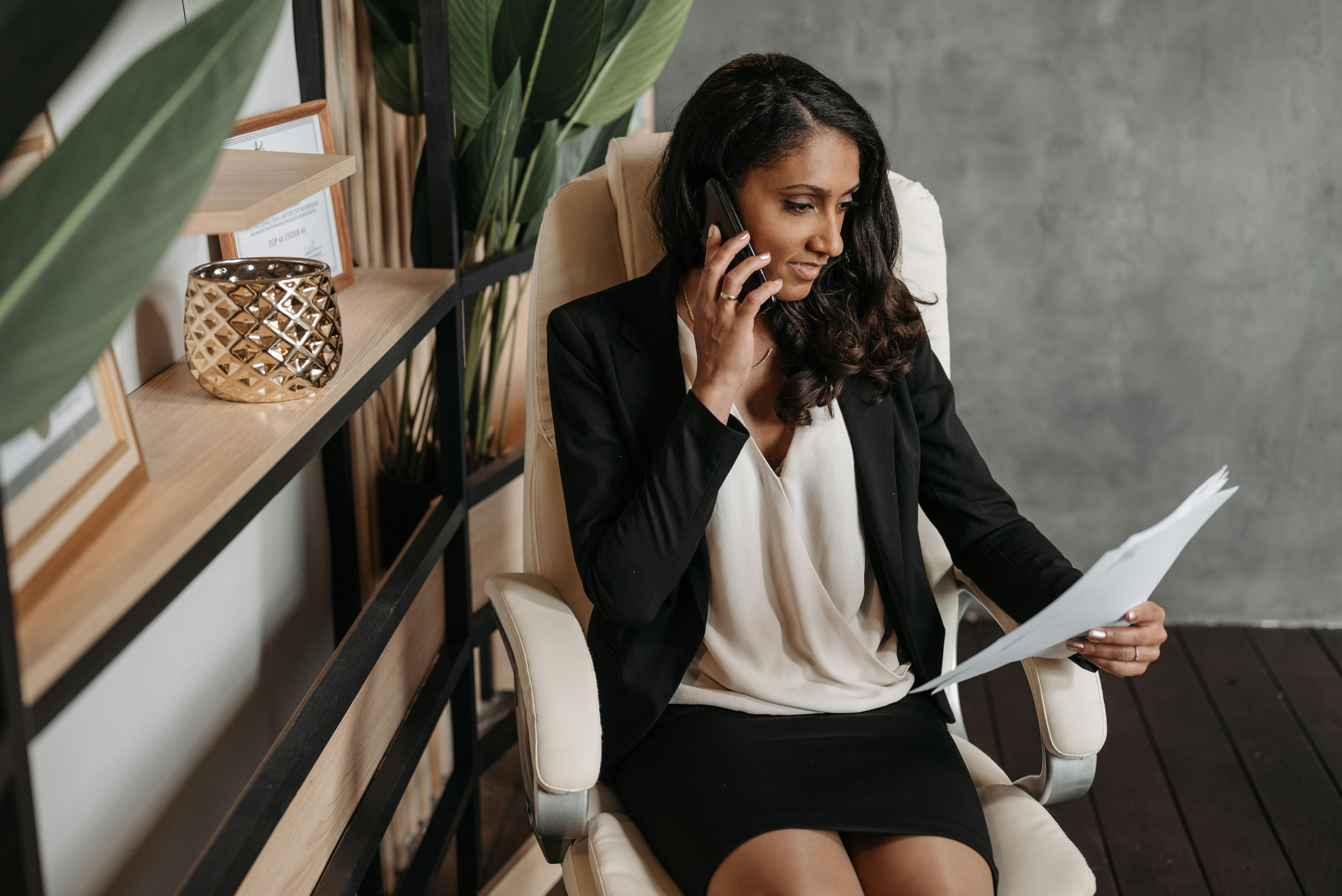 woman talking on phone and holding documents