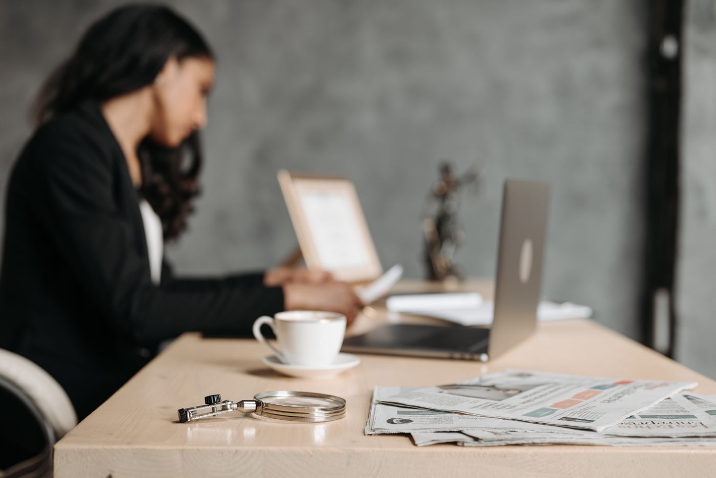An Apex Audit accountant working through client papers and figures at her desk
