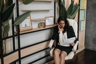 Woman in White Blazer Sitting on White Sofa Chair