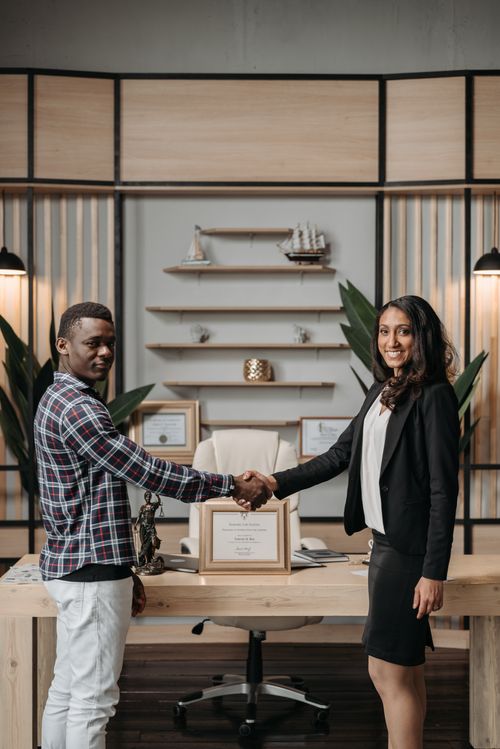 Free Business professionals shaking hands in a modern office, symbolizing collaboration. Stock Photo
