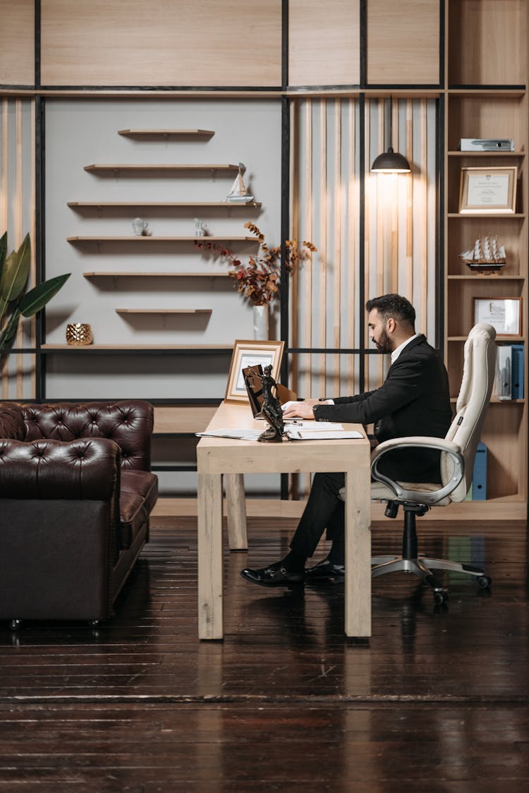 Man In Black Suit Sitting At His Office