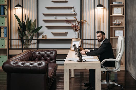 Man in a suit working at a desk in a well-designed modern office.