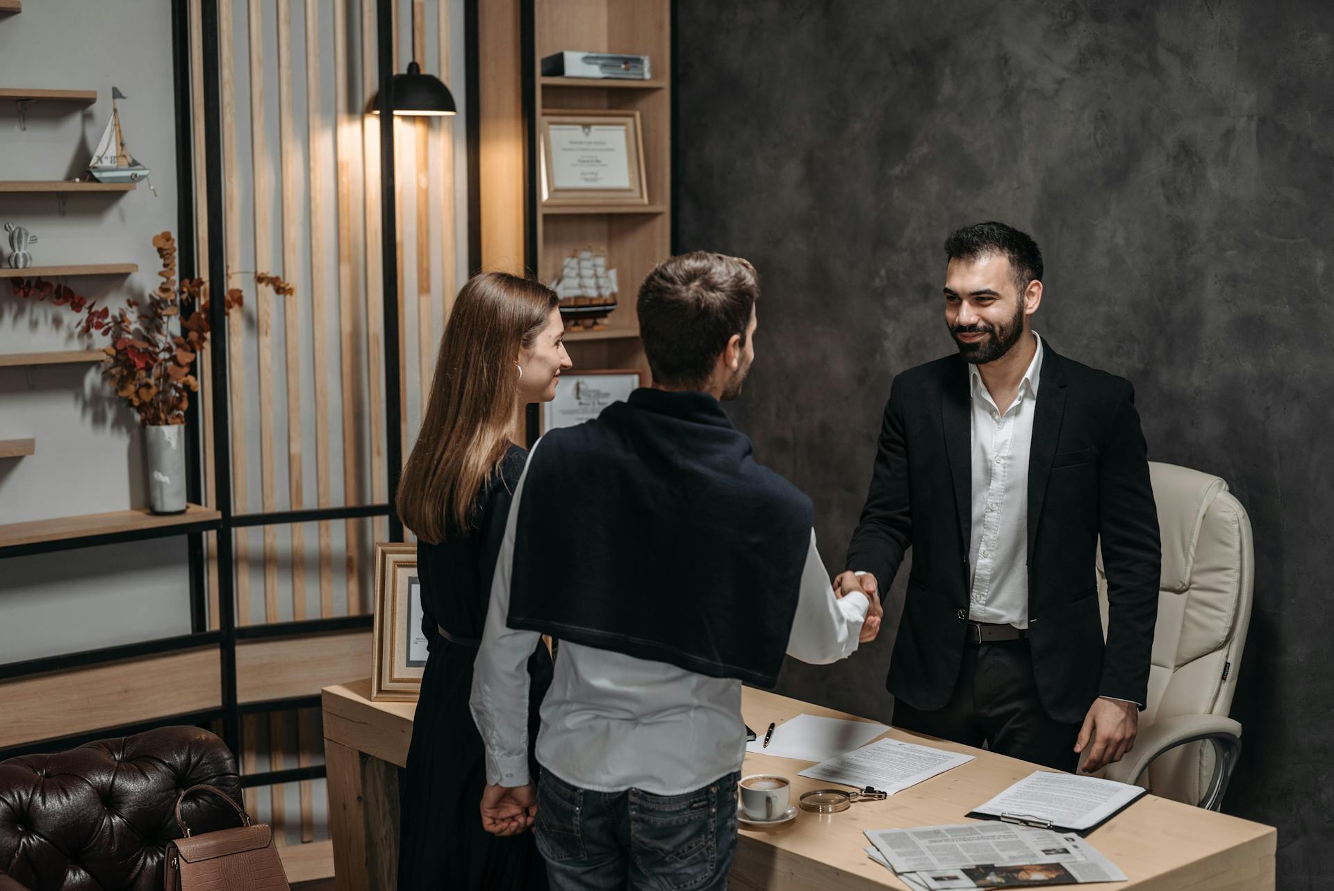 Professional business meeting in modern office setting with a handshake.