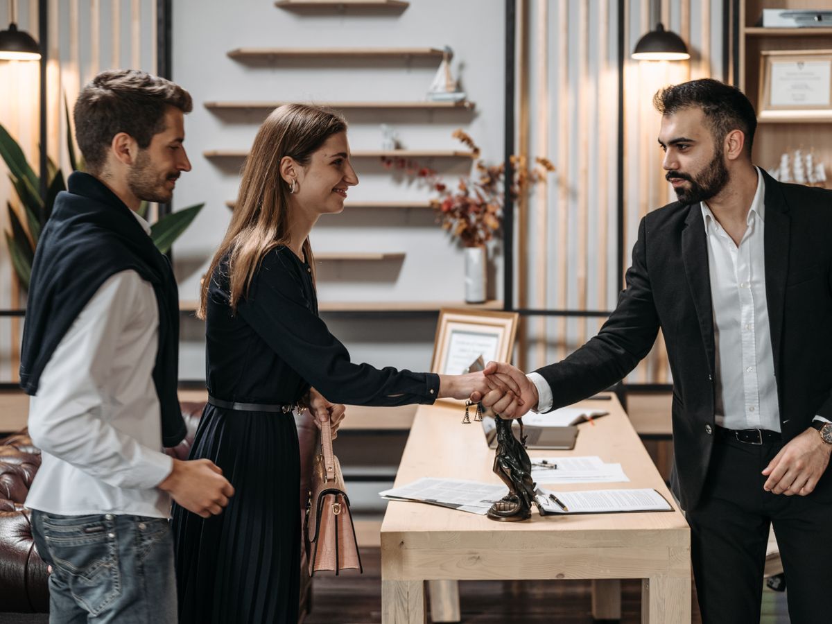Two professionals shaking hands after a meeting in an office