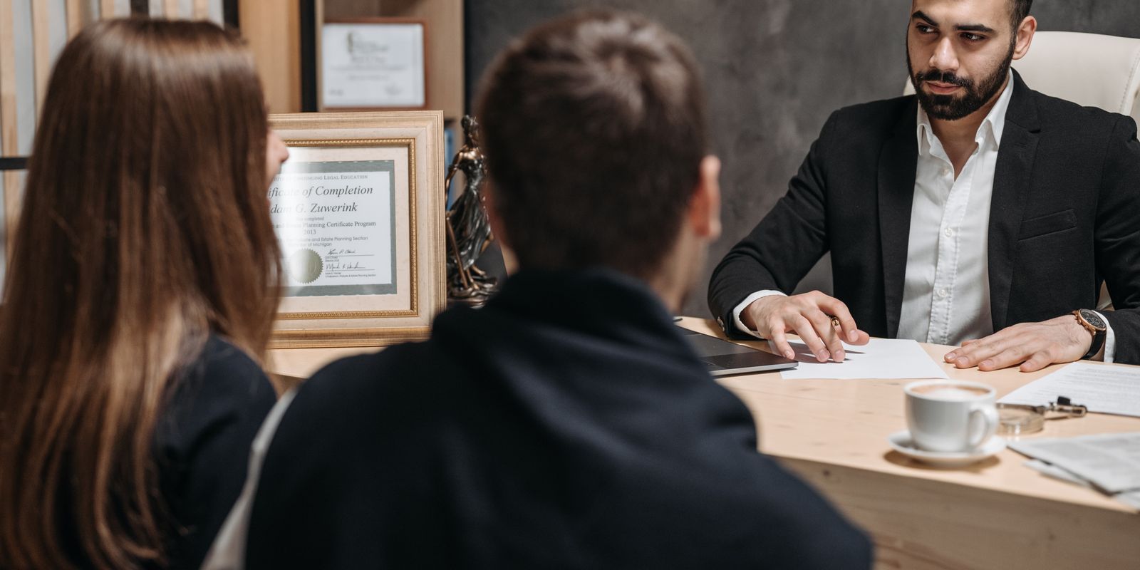 A business attorney meeting with clients in an office, walking them through their options.