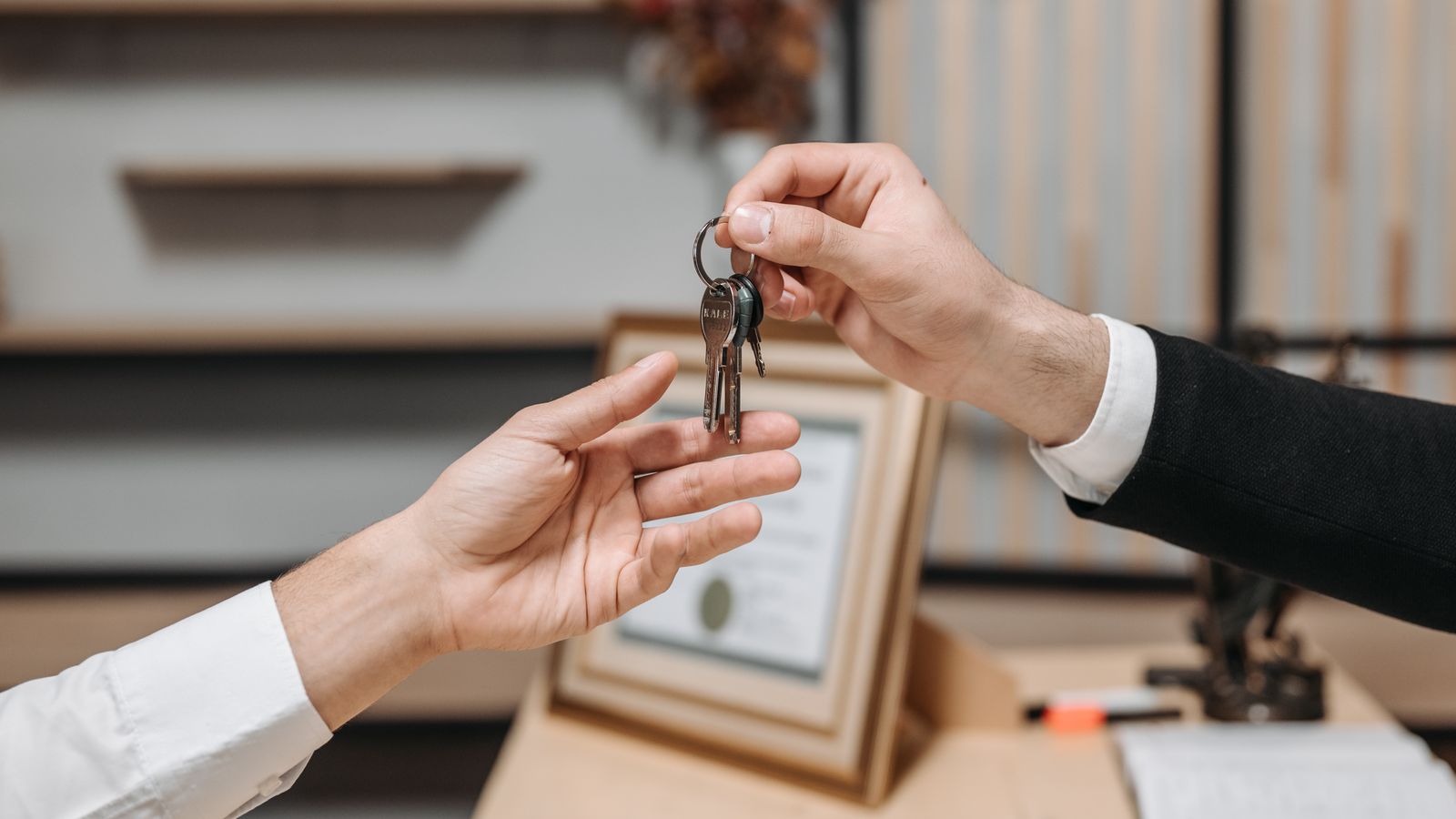 Person handing over keys, representing TEFL perks like housing provided with a teaching job abroad