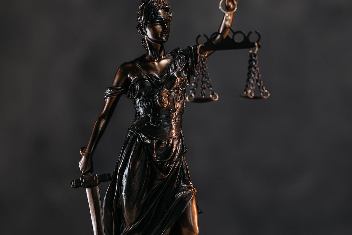 Elegant bronze Lady Justice statuette symbolizing law and justice. Elegant bronze Lady Justice statuette symbolizing law and justice.
