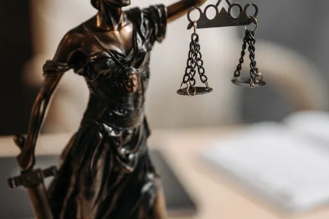 Bronze Lady Justice statue holding scales and a sword