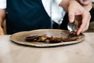 Person Slicing Meat on White Ceramic Plate