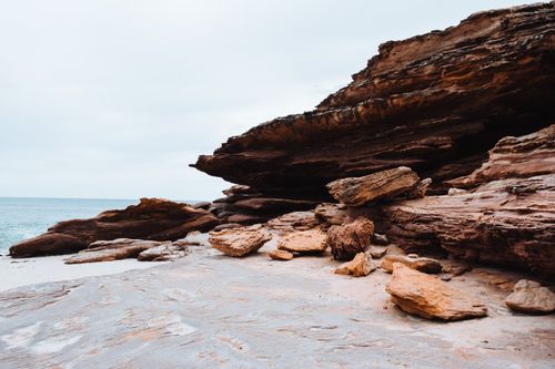 Free Impressive sandstone rock formations by the ocean, showcasing natural erosion and geological beauty. Stock Photo