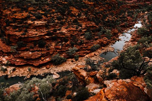Free Stunning aerial photograph capturing the vivid red rock formations and winding river of a desert canyon landscape. Stock Photo