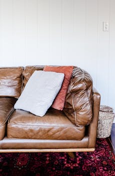 Brown leather sofa with cushions in a stylish, modern home interior setting.