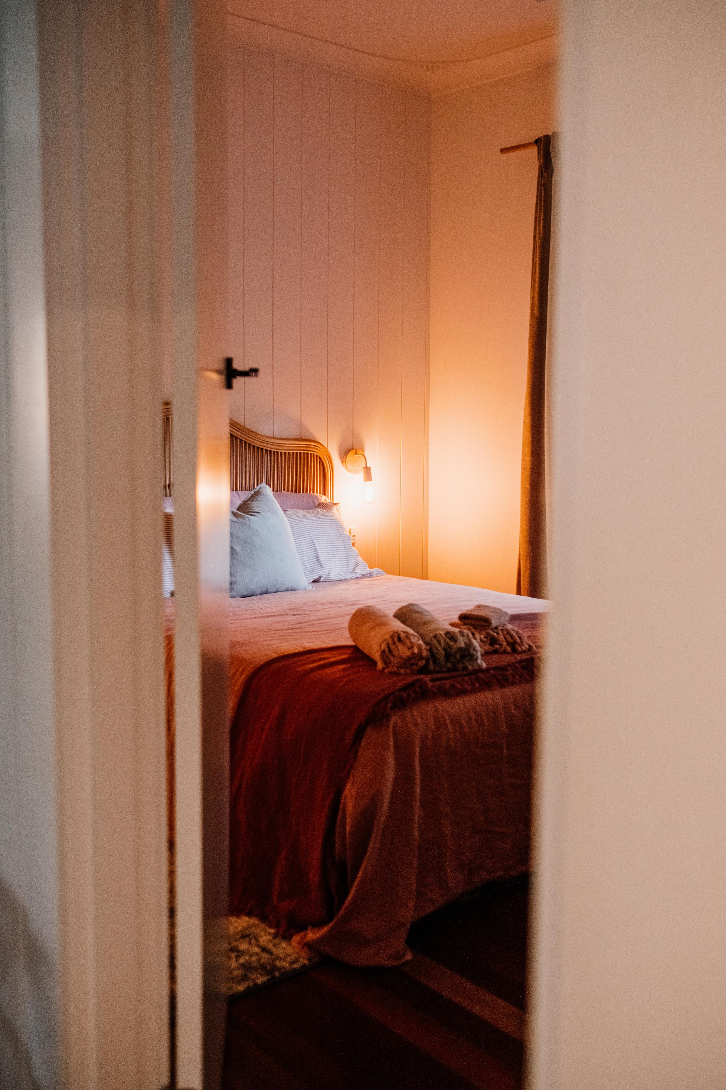 Atmospheric bedroom with a dark envelope, layered bedding and soft ambient light