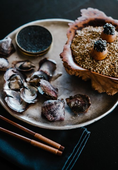 Free A luxurious seafood platter featuring caviar, oysters, and garnishes on a rustic plate, perfect for gourmet dining. Stock Photo