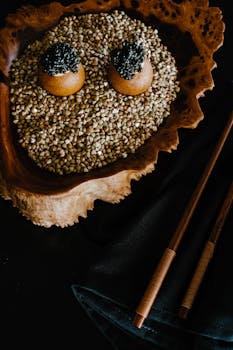 Top view of a luxurious caviar dish with chopsticks on a dark background.