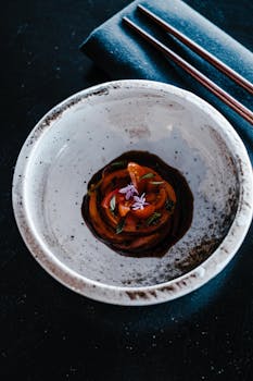 A beautifully plated gourmet sushi with artistic garnish in a ceramic dish, perfect for upscale dining visuals.