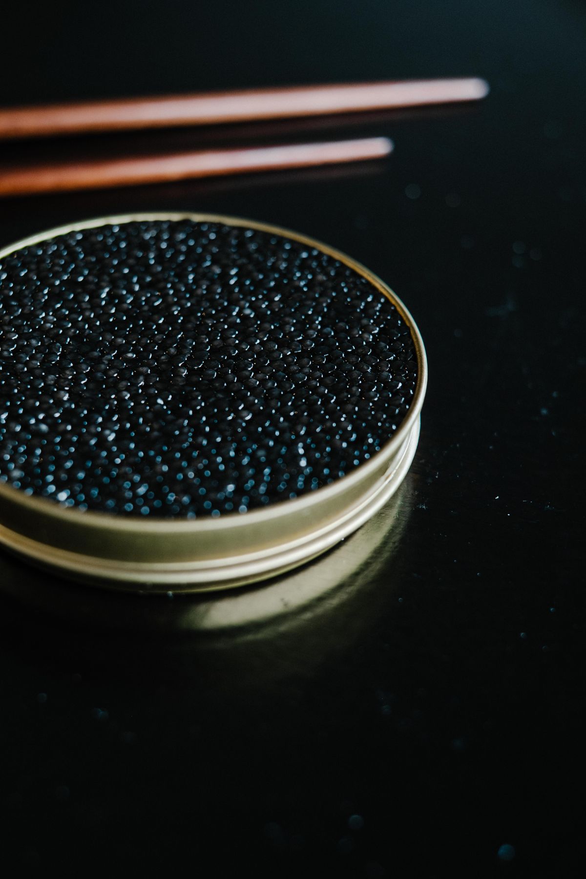 Hand picking up a single caviar crisp from white plate
