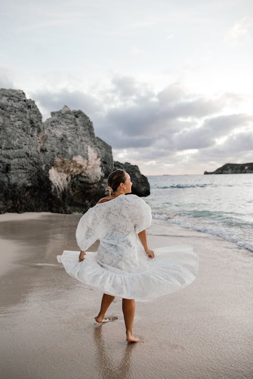 Free Woman in White Dress Standing on Beach Stock Photo