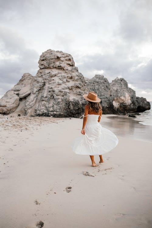 Woman Wearing White Dress Walking at the Beach