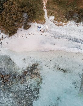 A stunning aerial shot showcasing a secluded beach with clear waters and surrounding greenery.