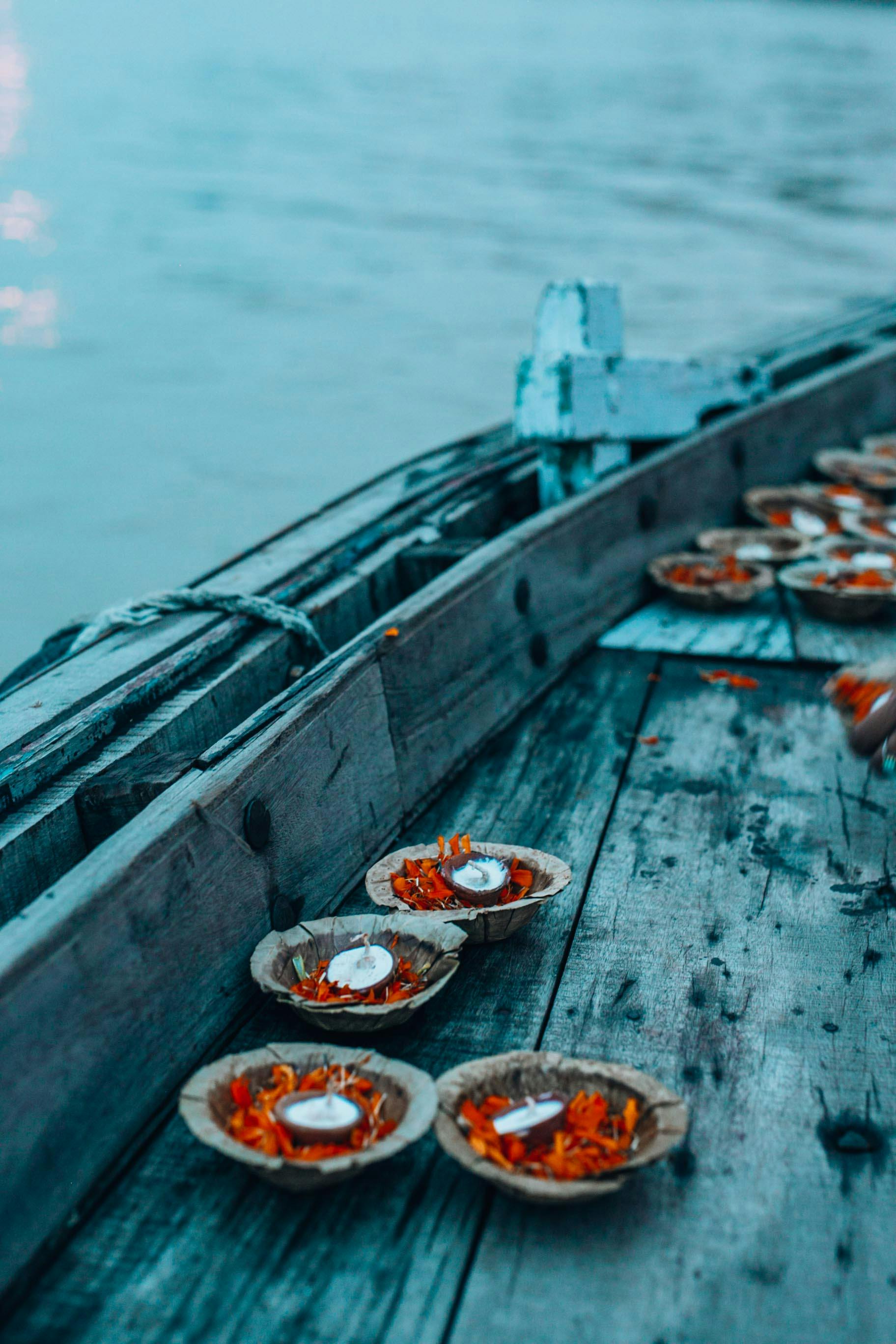 candles in little bowls on an old wooden boat deck