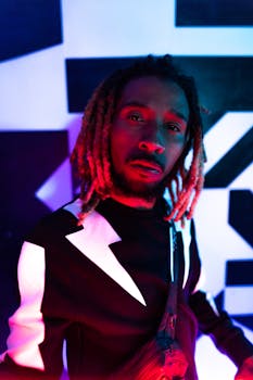 Dynamic portrait of a musician in trendy attire with colorful neon lighting creating a vibrant atmosphere.