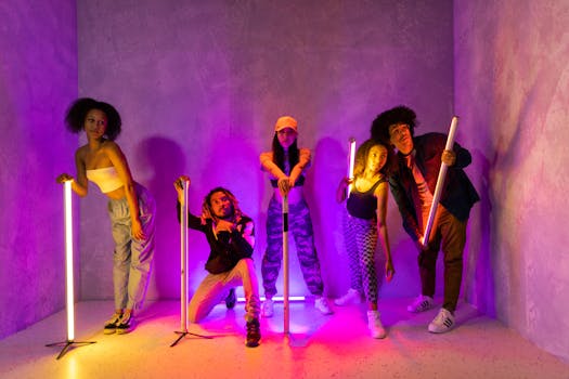 A diverse group of young adults posing creatively with neon lights in an urban setting.