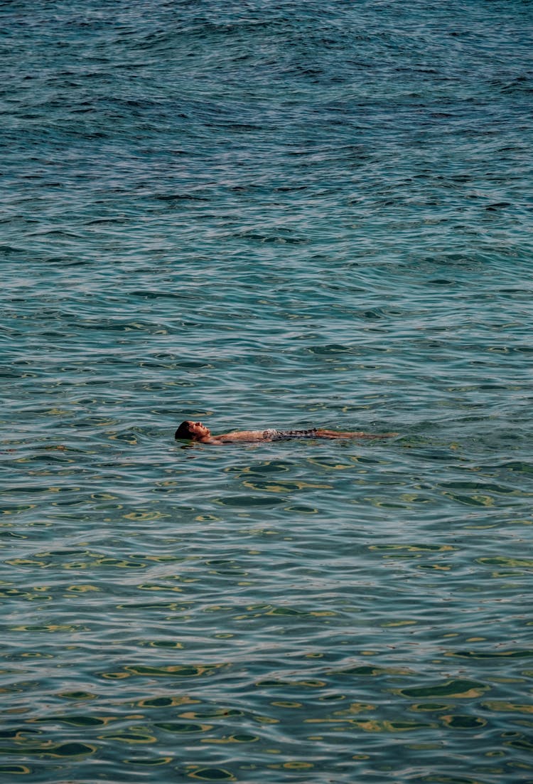 A Man Floating On A Sea