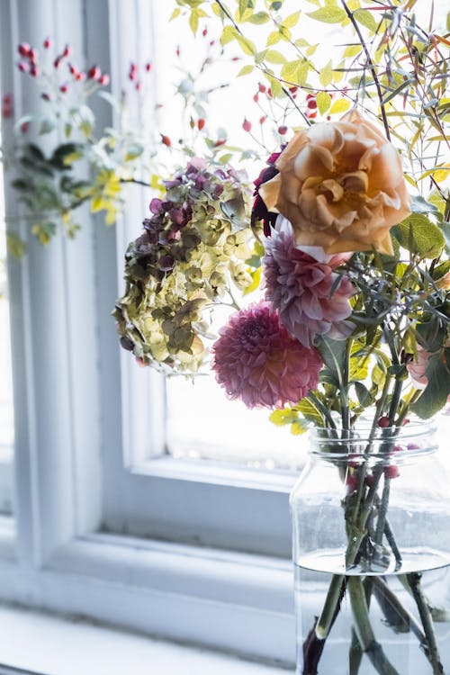Beautiful Bouquet in a Glass Vase Standing on a Windowsill 
