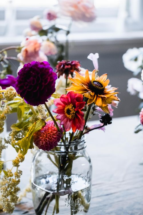 Free Colorful flowers in a rustic glass jar with natural light. Stock Photo